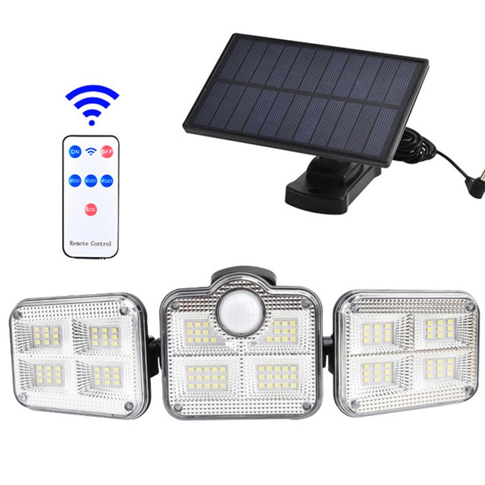 Black solar panel with a 3 headed security motion light beneath and a remote control