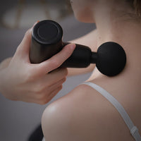 Thumbnail for A female model using a black No More Sore Mini Massager And Muscle Toner