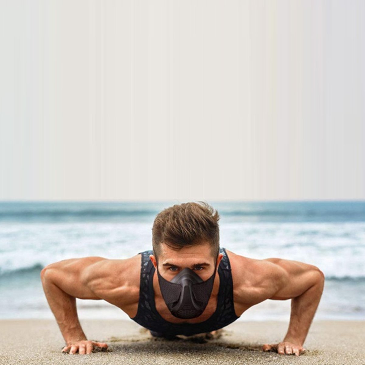 A male model doing pushups on the beach wearing the Premium Cardio Workout Sports Mask