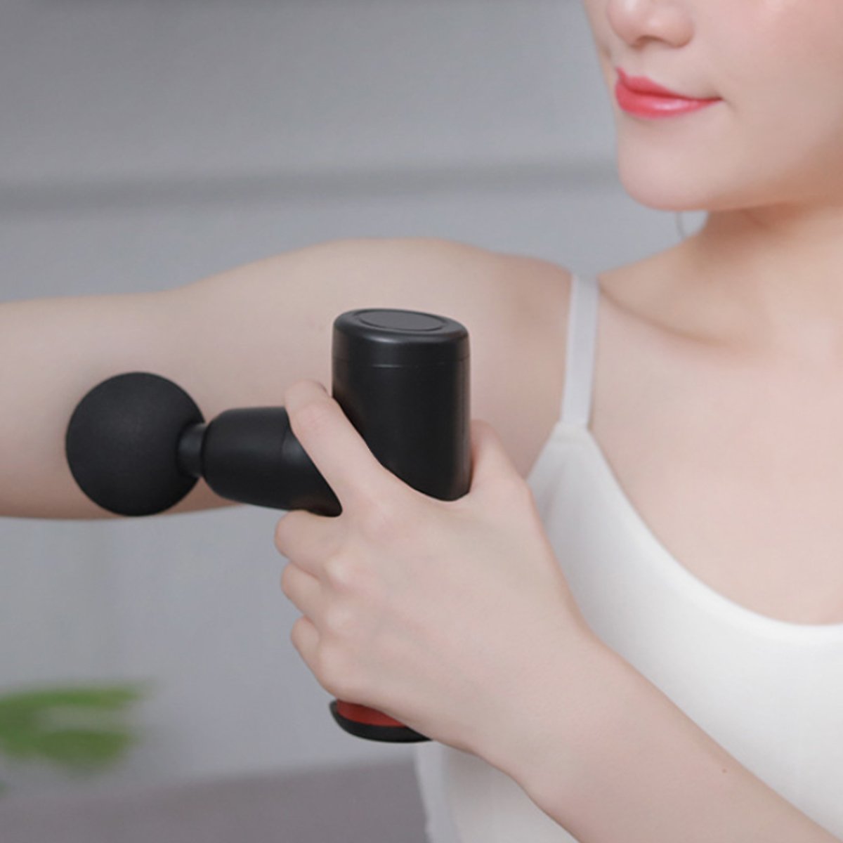 Shows female model using the No More Sore Mini Massager And Muscle Toner for her arm