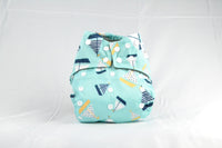 Thumbnail for A teal green Earthlie Cloth Diaper Boat with black and white sail boats decorating the outside of it