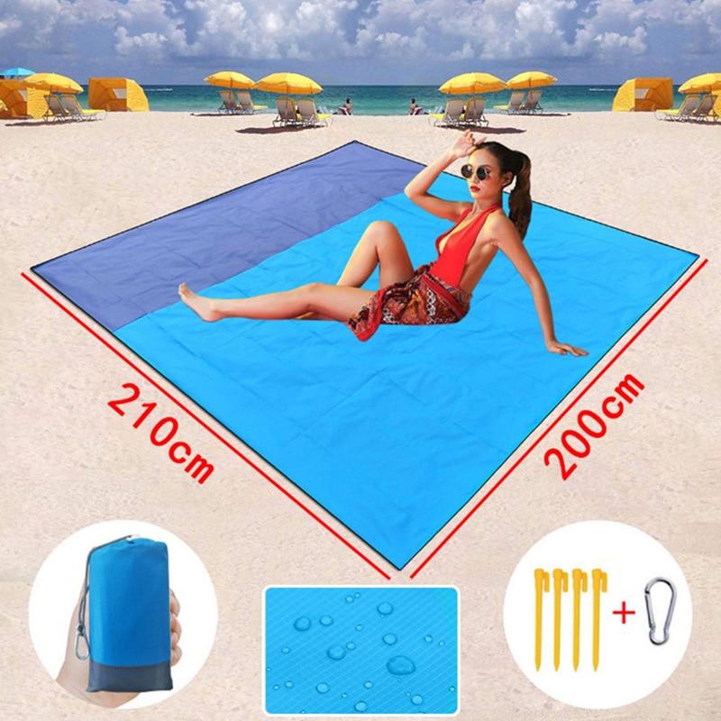 Waterproof Beach Blanket being used by a female model on the beach and shows the dimensions 210 cm by 200 cm 