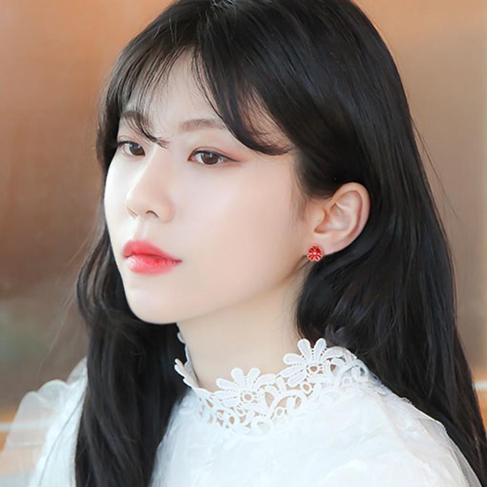 A female model shown wearing a set of Daisy Red Stud Earrings with 14K Gold Pin