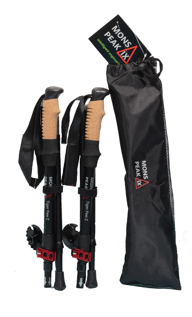 A set of Mons Peak IX Tiger Paw Z Trekking Poles (Z-135) they have tan cork colored handles and a black body with white writing on them The included black carrying case is shown sitting next to them