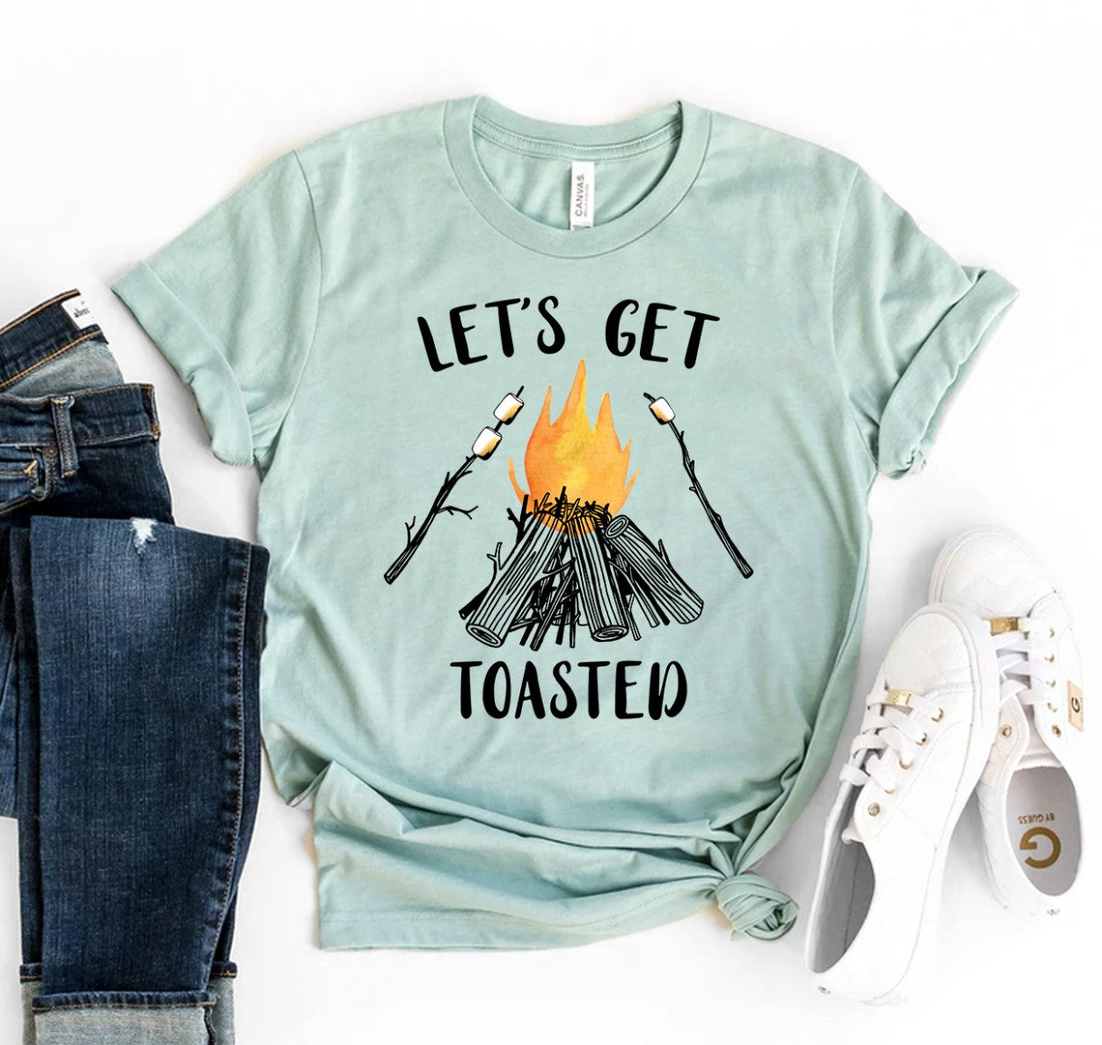 A teal green Lets Get Toasted T-shirt shown with a pair of blue jeans next to it and a white pair of tennis shoes