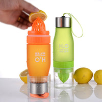 Thumbnail for A lemon is shown being squeezed from within two infuser bottles that are orange and green respectively