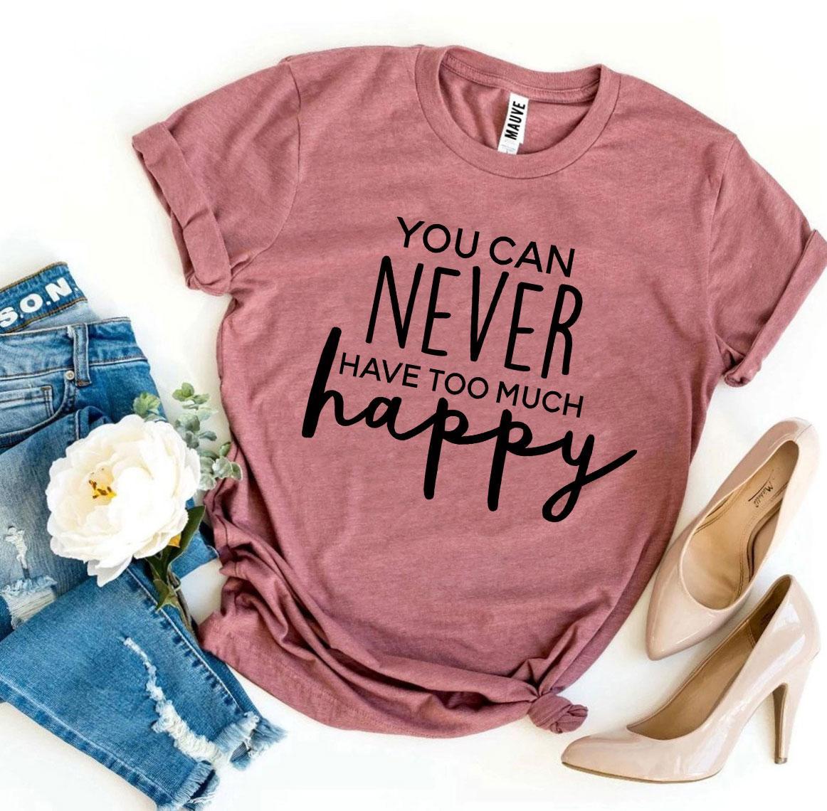 A dusty rose pink You Can Never Have Too Much Happy T-shirt with a pair of blue jeans and tan heels sitting next to it