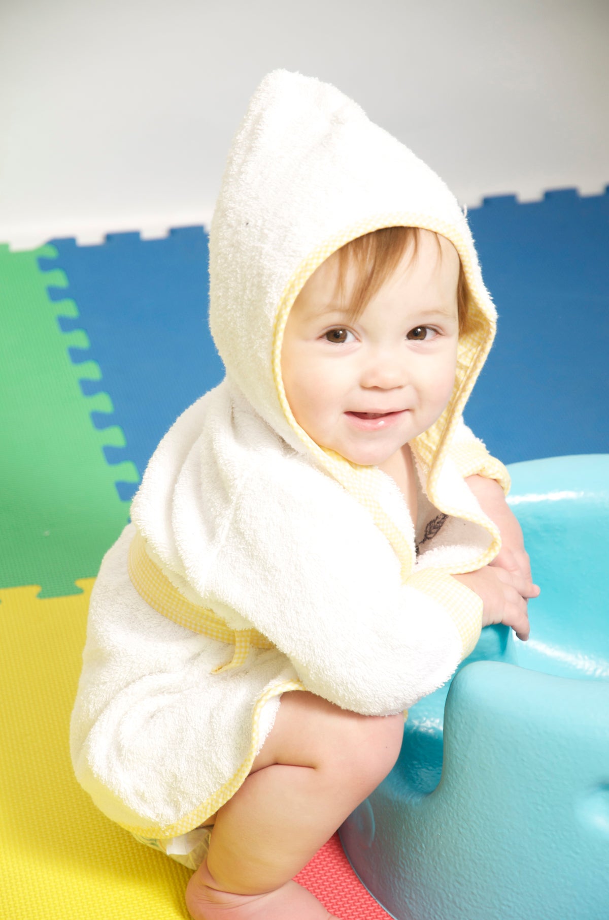 A small child shown wearing a 80/20 Bambini Terry Cloth Robe 