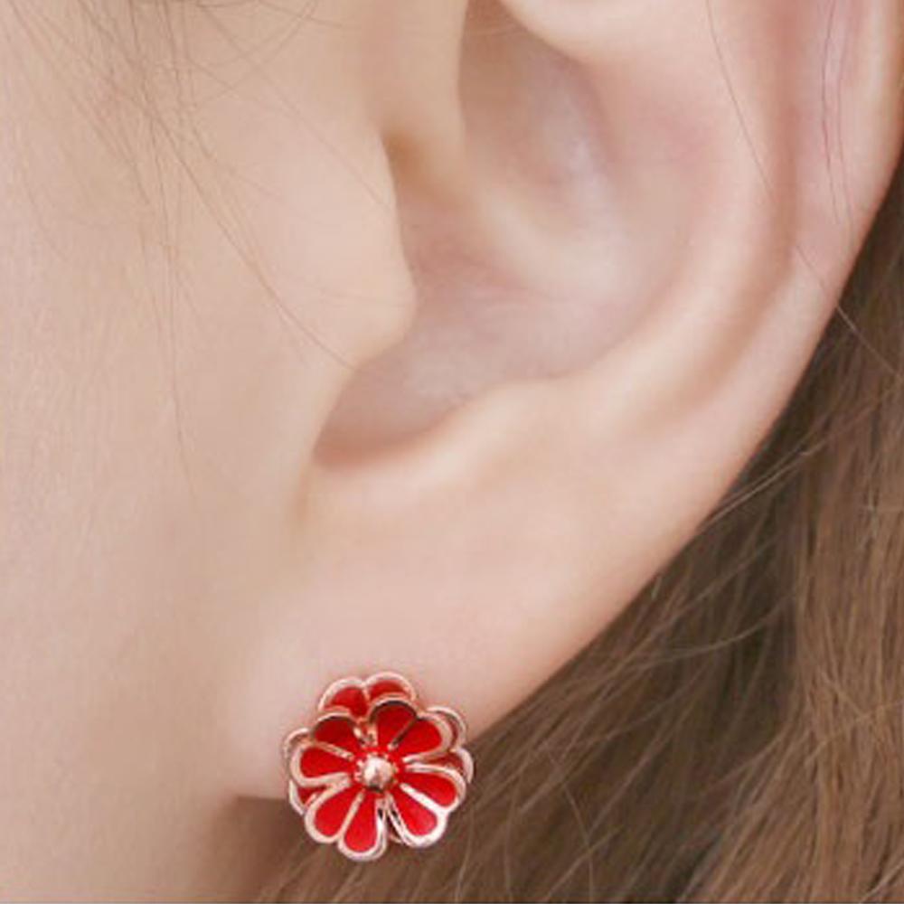 A close up of a female models ear shown wearing Daisy Red Stud Earrings with 14K Gold Pin in red and gold