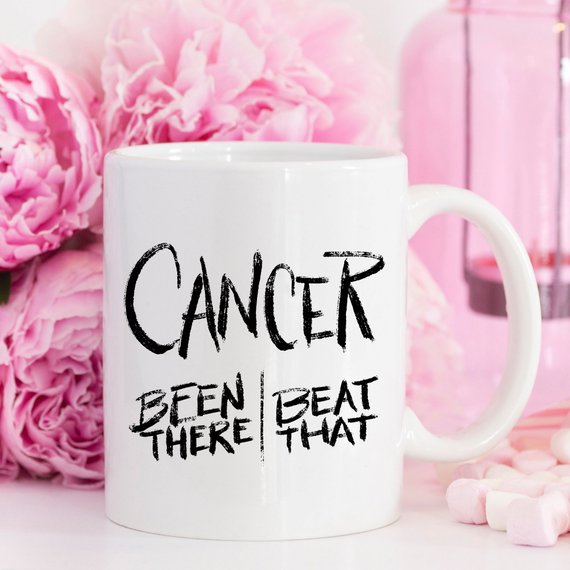 A Cancer Survivor Been There Gift Mug with breast cancer awareness pink flowers sitting behind it