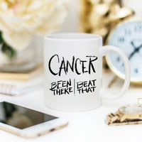 Thumbnail for A Cancer Survivor Been There Gift Mug sitting on a table next to a cellphone and rolex watch