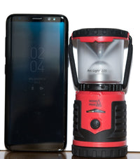 Thumbnail for A Mons Peak IX Arc Light 225 AA LED Lantern shown sitting next to a phone for size comparison its slight shorter than the cell phone