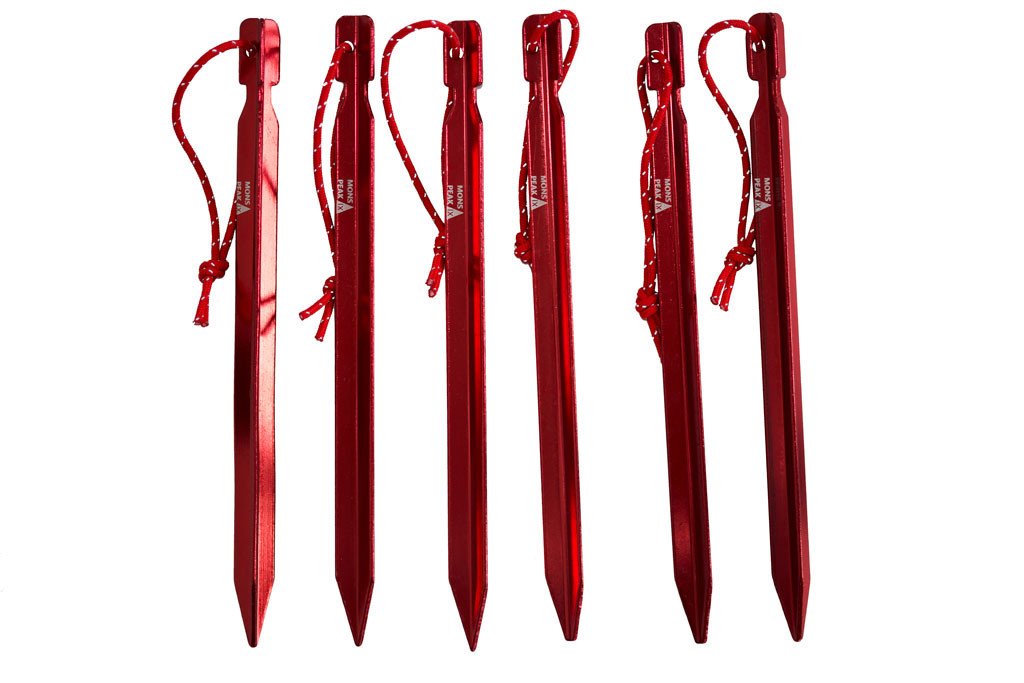 Shows a set of Mons Peak IX Tent Stakes, (6 Pack) they are a metallic red in color with white writing on them