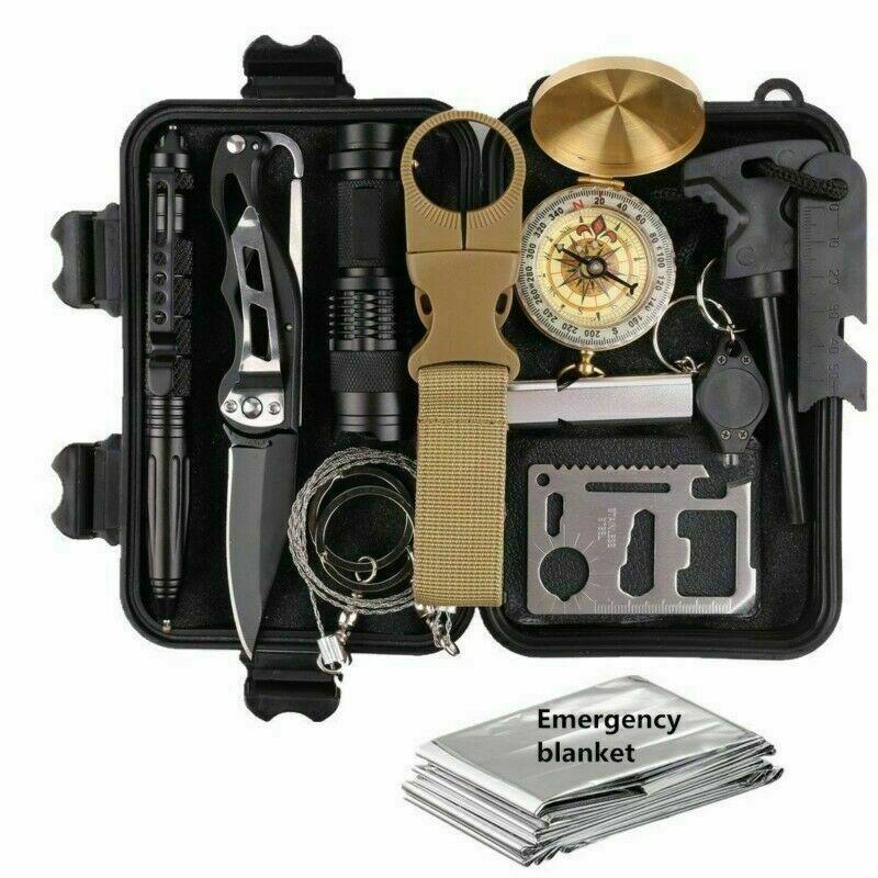 An exploded view of a black survival kit fully opened.  Displaying a knife flashlight compass fire striker wire saw tactical pen emergency blanket carabiner and a sercurity multi tool card